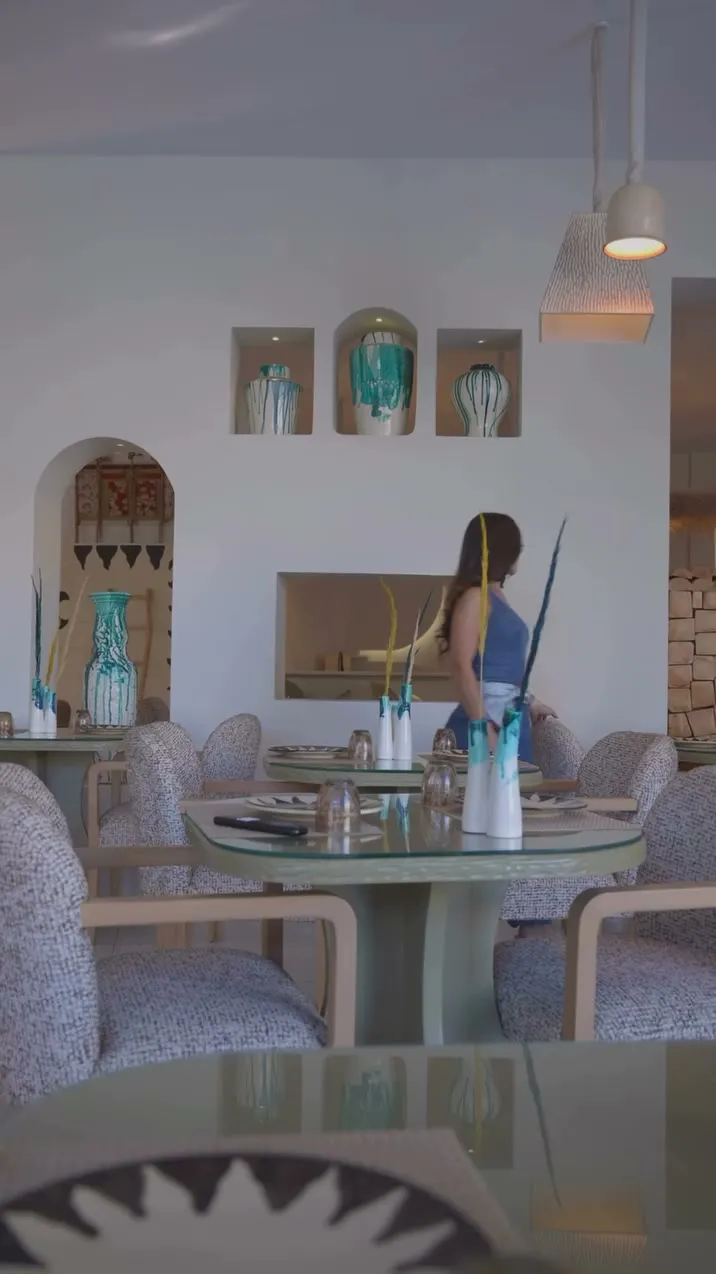 Salle du restaurant du Carthage Thalasso : niches, vases, assiette Soleil au premier plan