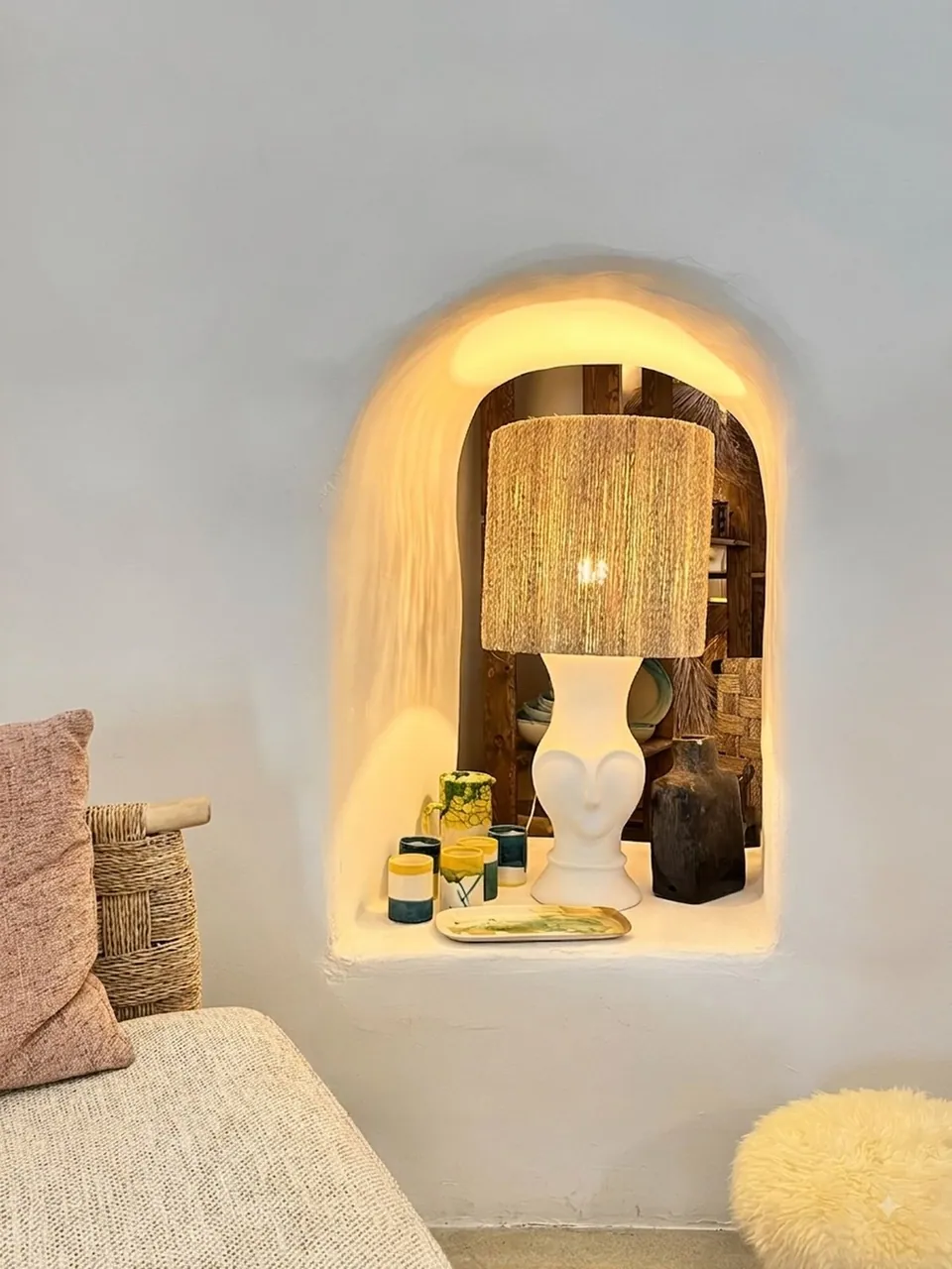 Lampe en raphia allumée dans une niche en plâtre